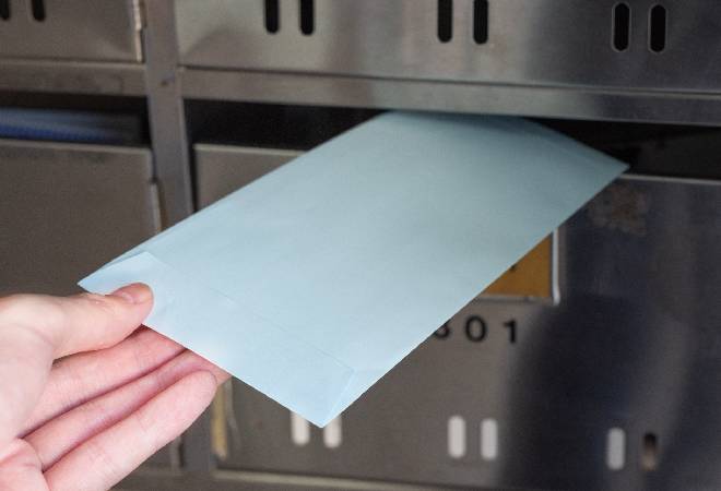 郵便受けに封筒を入れているところ。