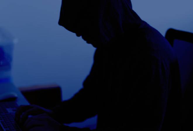 パソコンを操作する男性の不穏な影。