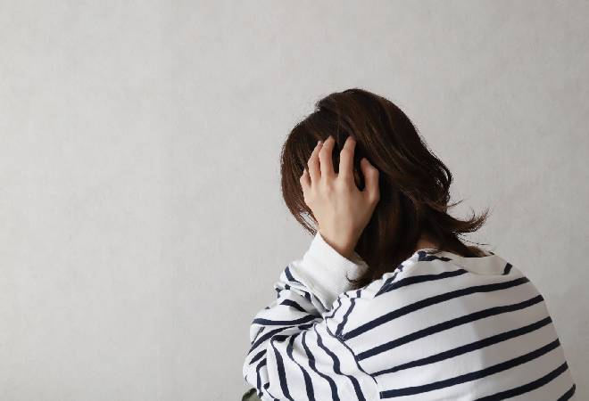 頭を抱える母親。