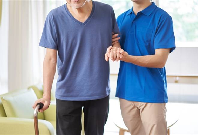 男性を介護する女性職員の姿。